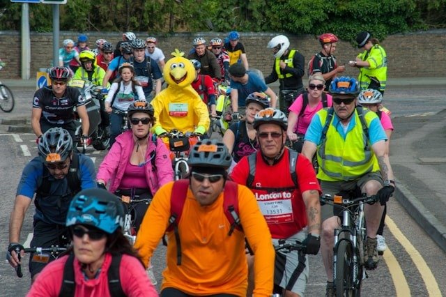 Biker in a bird costume standing out, like your ad copy should do, in a race with other bikers