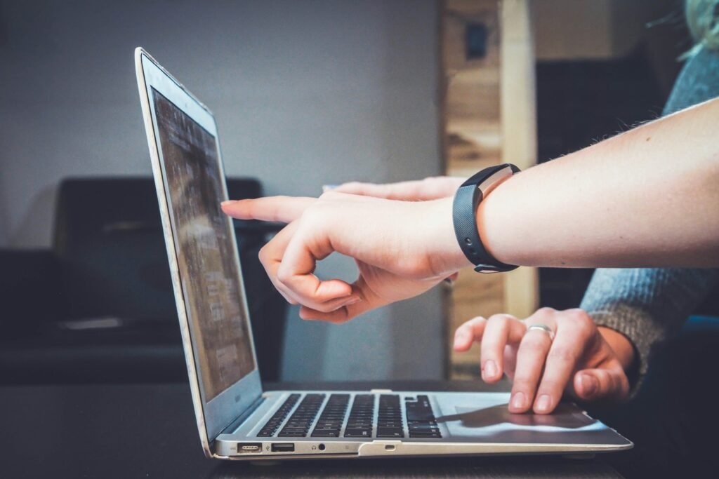 People pointing at a laptop screen trying to decide on which software is right for their business